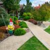 Gele tuinkabouter met bezem in tuin
