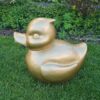 Belle een grote gouden badeend voor je tuin. Tuinbeeld in de vorm van een badeend, een speelse toevoeging aan de tuindecoratie.