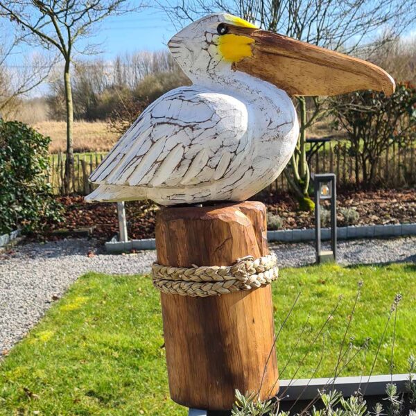 Deze houten pelikaan op een stronk (ca. 50 cm hoog) is een unieke, handgemaakte blikvanger voor binnen en buiten. Met de hand gesneden en geschilderd