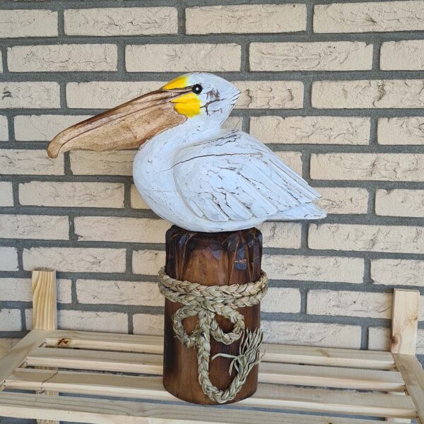Deze houten pelikaan op een stronk (ca. 50 cm hoog) is een unieke, handgemaakte blikvanger voor binnen en buiten. Met de hand gesneden en geschilderd