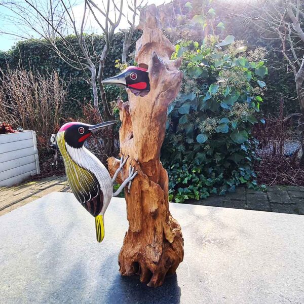 Deze houten specht met jong op een moerashouten stronk is met de hand gesneden en geschilderd in Indonesië, waardoor elk exemplaar uniek is. Circa 40 cm hoog